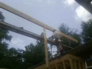 Carpenter setting a ridge beam over a new addition frame — Ice Dam Removal by Roofing Brothers in Union Point