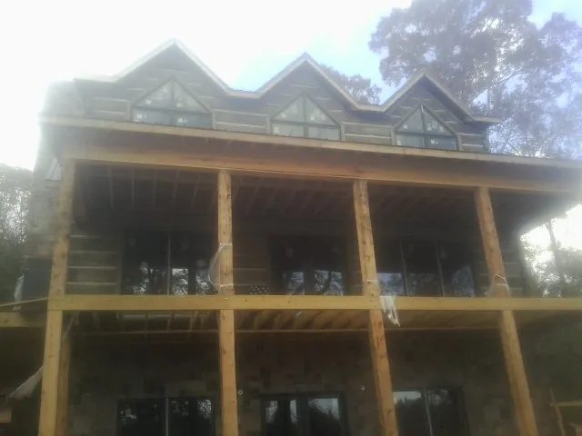 Dormers and porch framing on a large log home under construction — Roof Coating work by our crew in Union Point