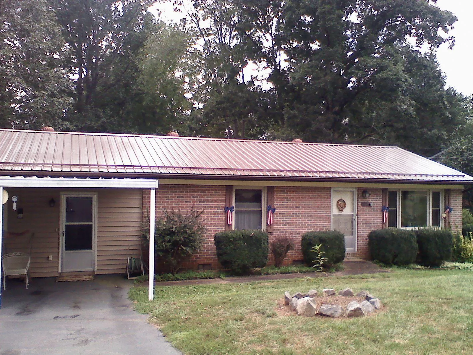 Bronze metal roof and carport on a brick ranch home — Roof Repair work by our crew in Union Point